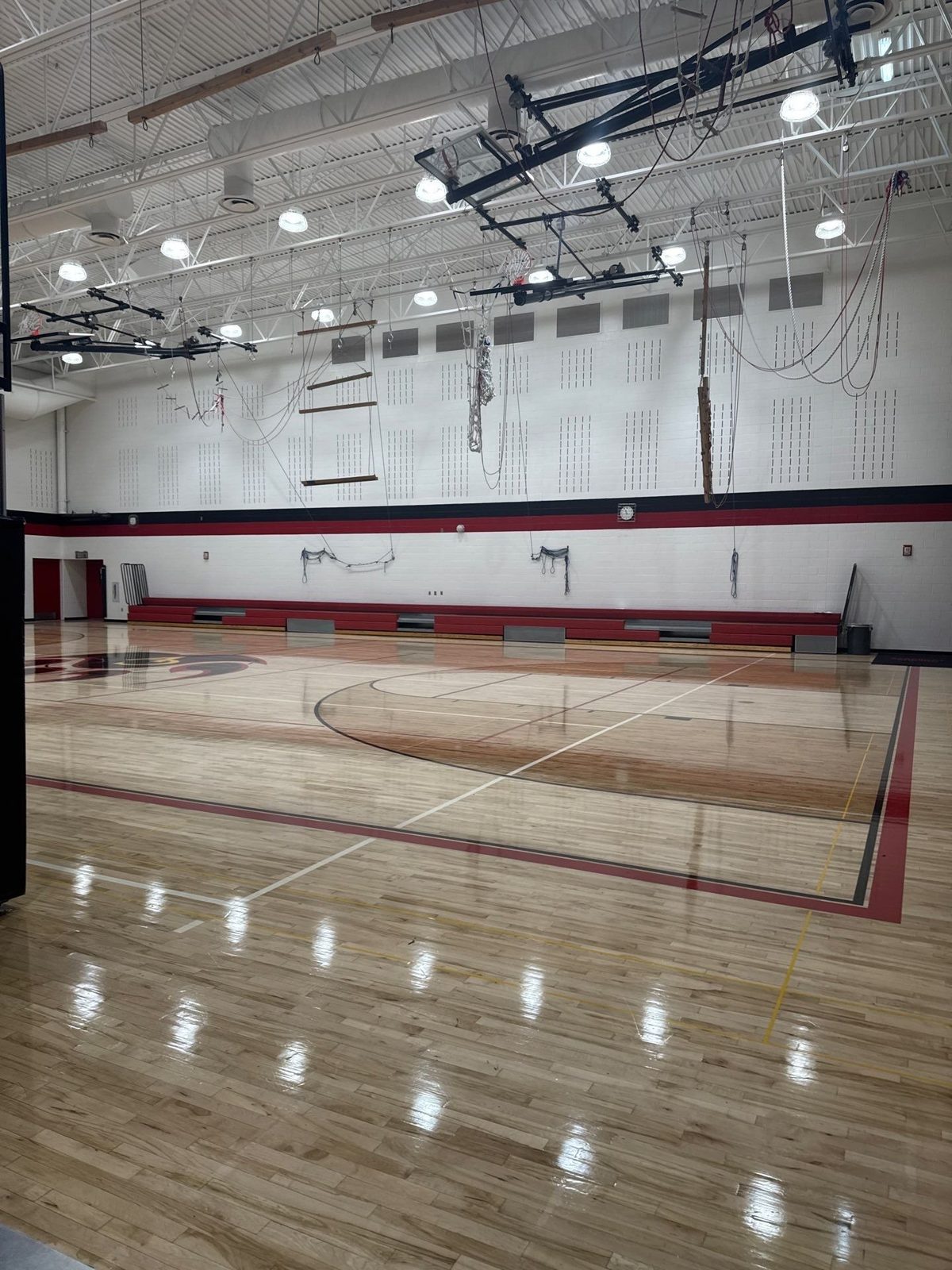 Castle View High School gym after commercial painting by H3 Painting, with white block walls and banding along the far wall