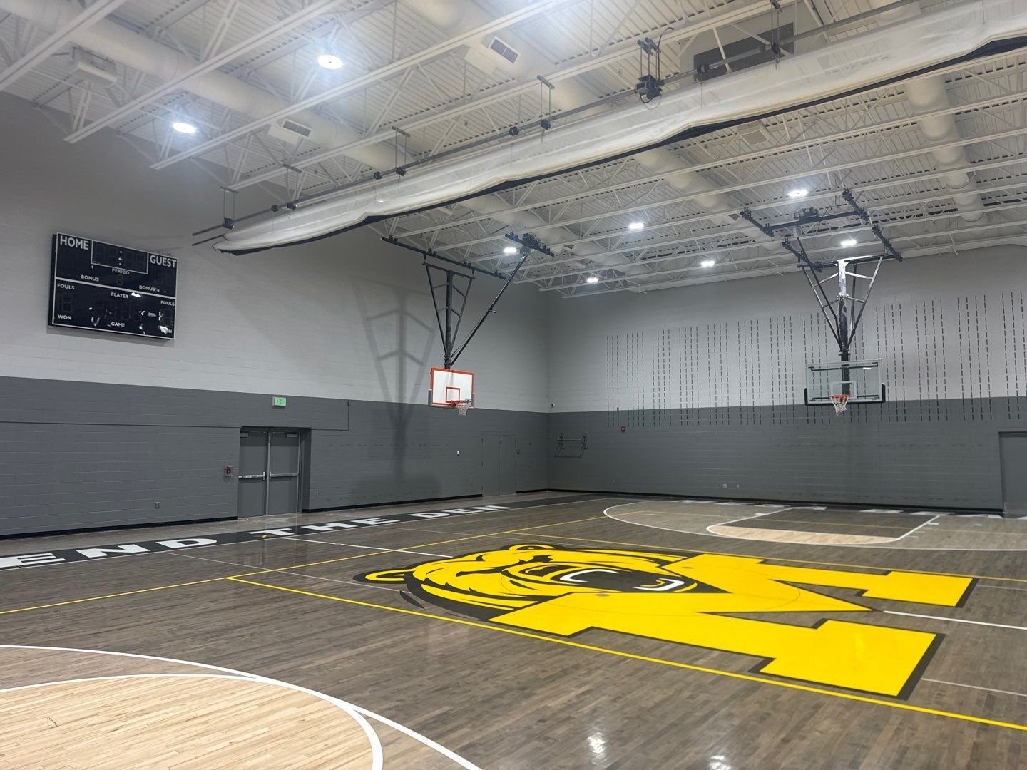 Repainted Mesa Middle School gym wall with scoreboard and basketball hoops