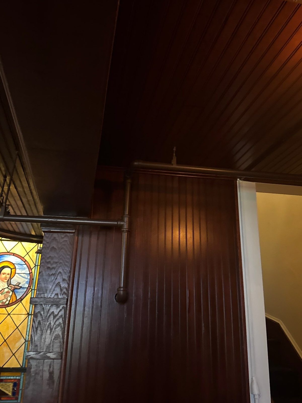Wood ceiling and paneling with painted exposed pipes inside Scileppi's at the Old Stone Church