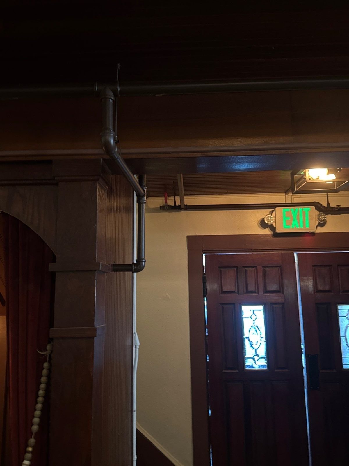 Interior wood trim, painted exposed piping, and entry doors at Scileppi's in Castle Rock